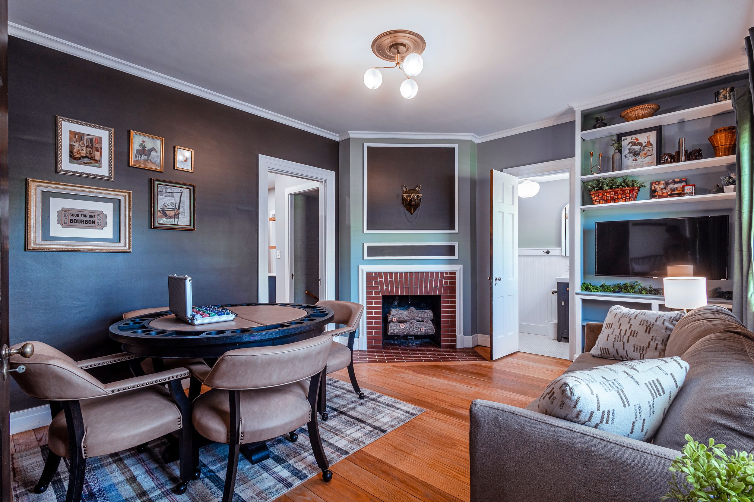 Contemporary living space with gray walls, ceiling fan and entertainment area setup.