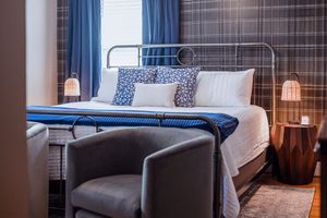 Contemporary bedroom with blue accents, metal bed frame, and modern side tables with lamps.