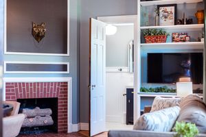 Modern living room with built-in fireplace, wall-mounted wolf art, and entertainment center with shelving.