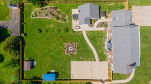 Drone shot of residential properties showing rooftops and backyards in a suburban setting.