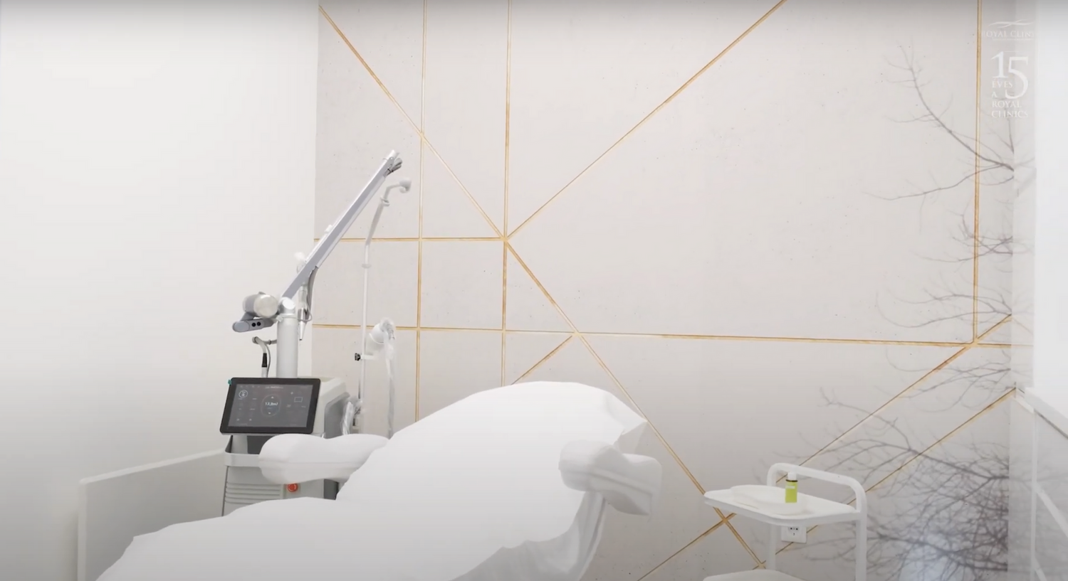 Clean medical examination room with white equipment and geometric wall design.
