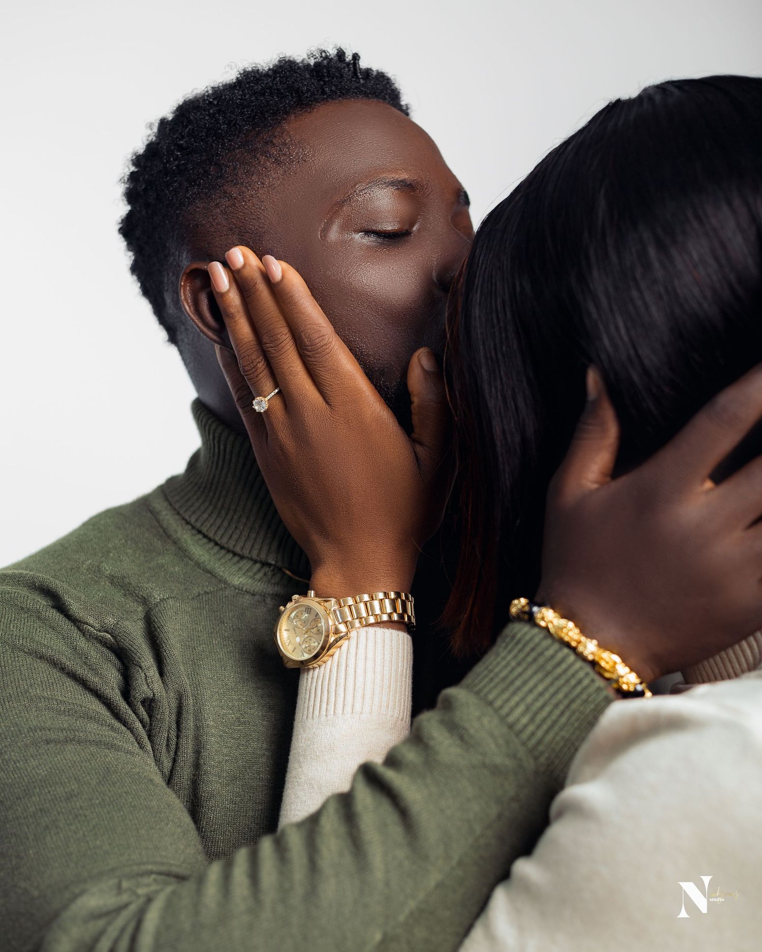 A tender embrace between a couple with elegant jewelry and cozy sweaters.