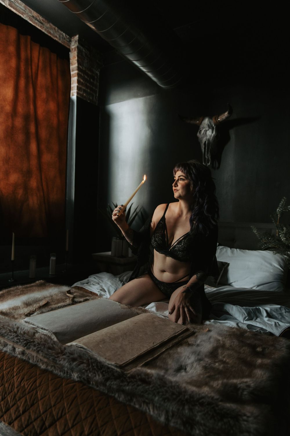 Dimly lit bedroom scene with candlelight and gothic-inspired décor.