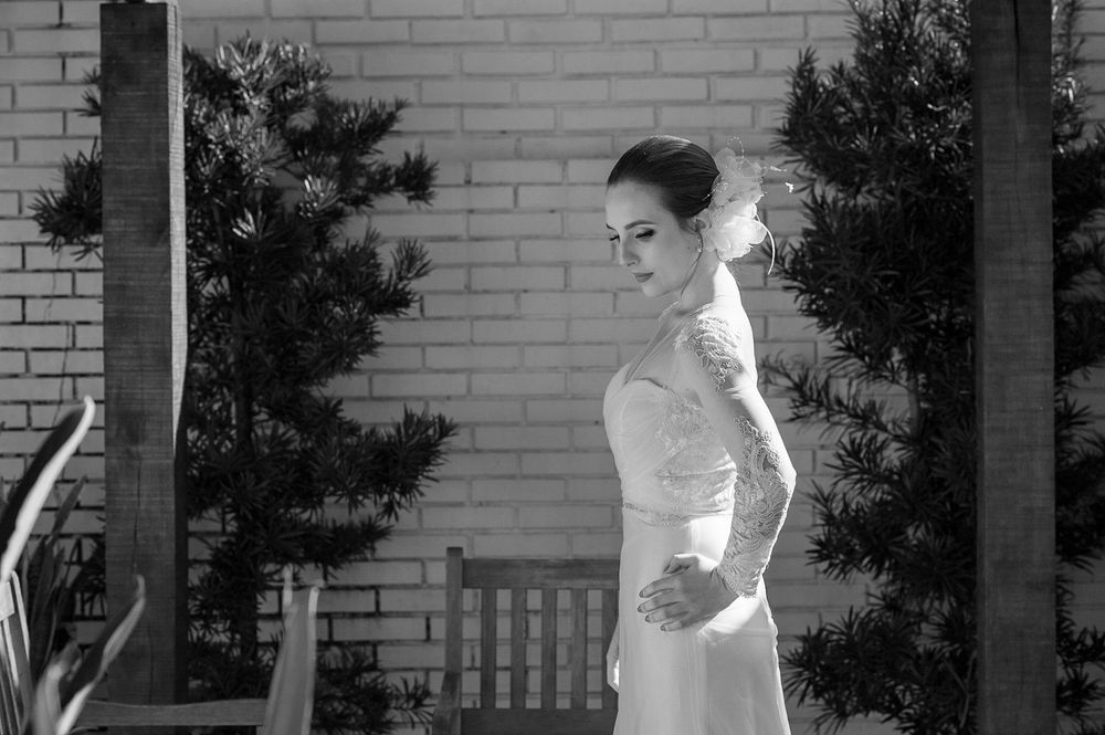 Elegant bridal portrait against a white brick wall background.