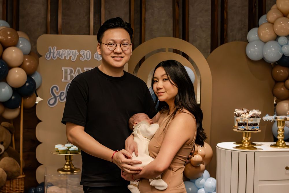Baby celebration event with elegant balloon arch and decorative backdrop.