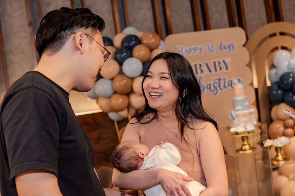 Baby celebration party with balloon decorations and intimate gathering indoors.