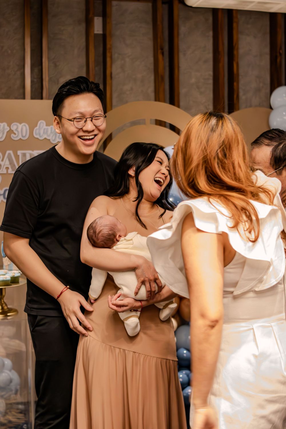 Joyful celebration moment at a baby party with balloon decorations.