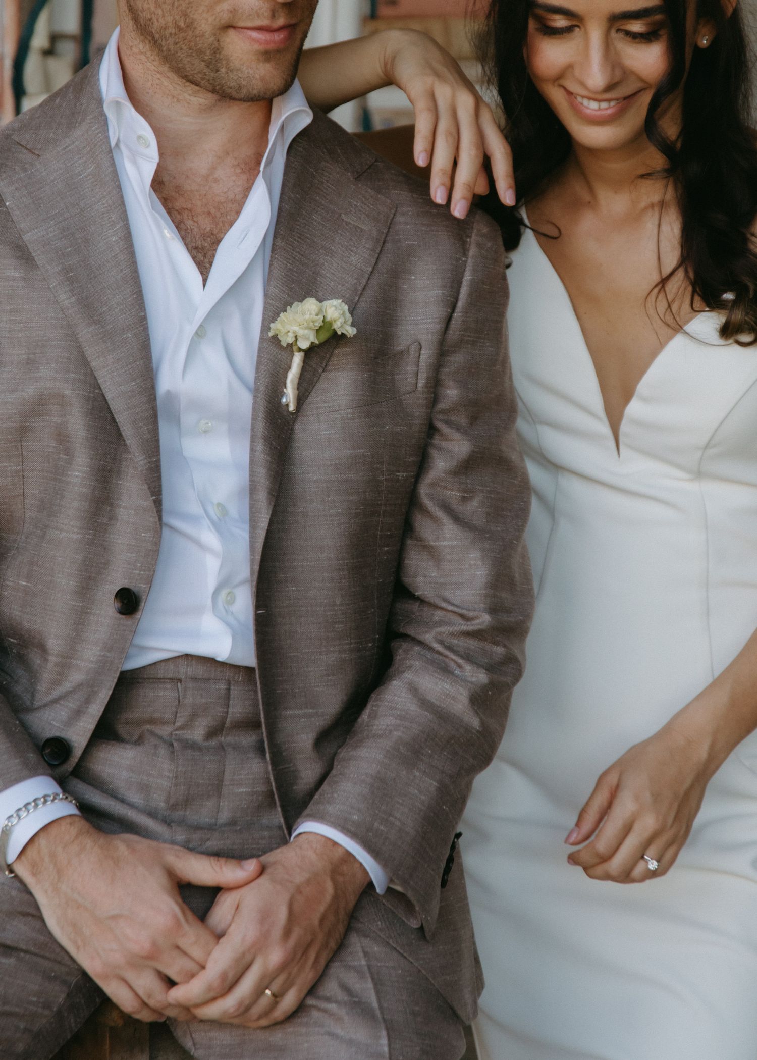 Couple in casual wedding attire shares intimate moments in natural light.
