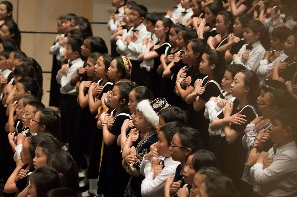 Children’s choir mid-performance on stage at a New York City concert venue