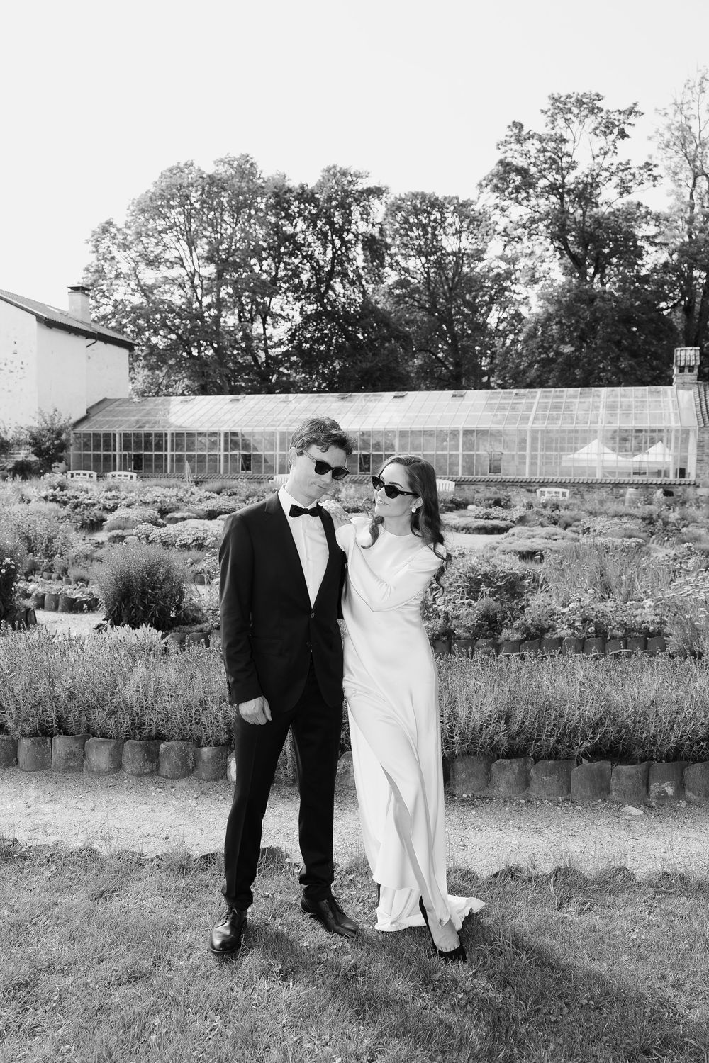 Wedding couple takes casual stroll through garden landscape.