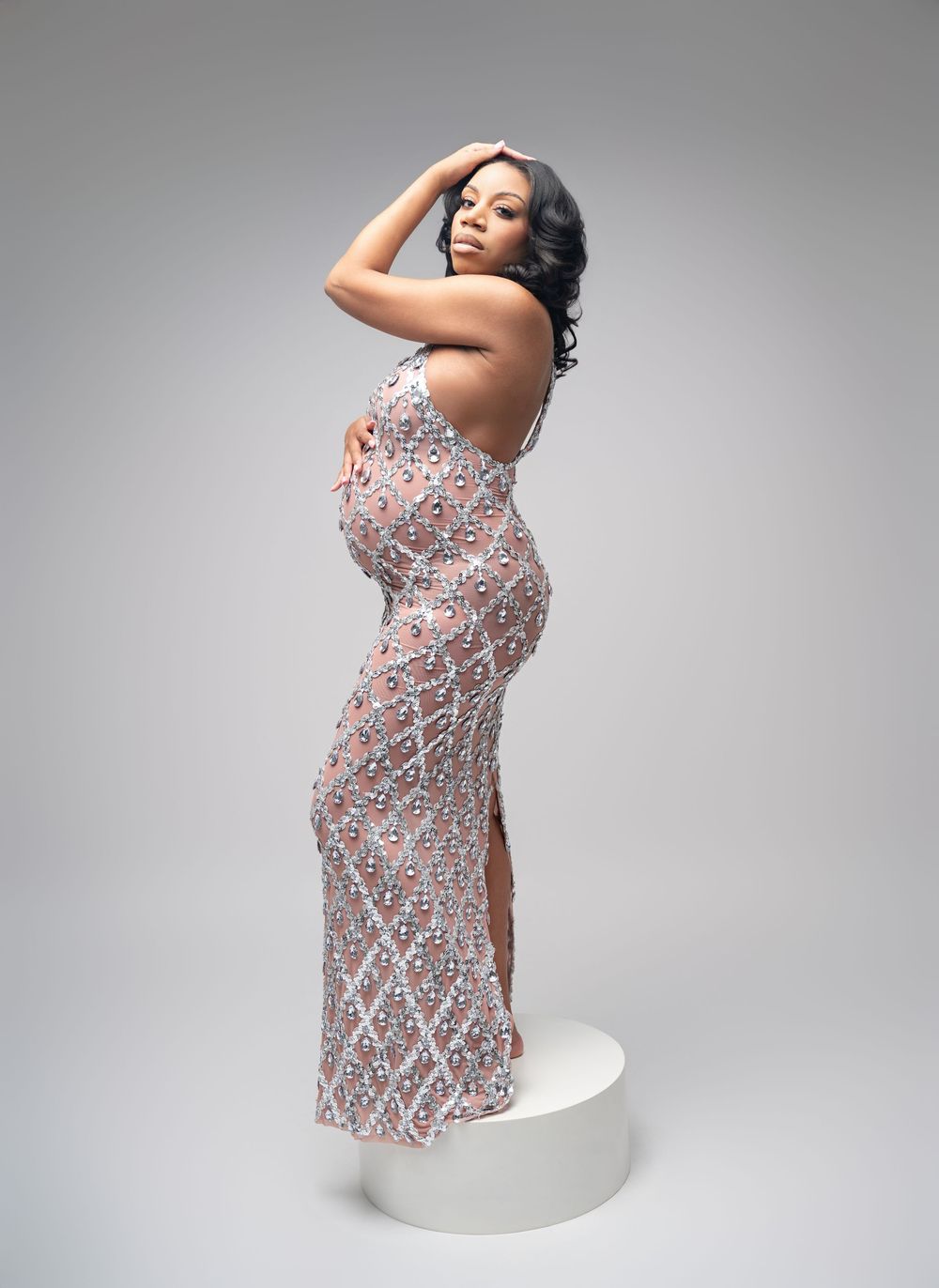 A person in a patterned dress poses gracefully against a light gray background in a series of artistic portraits.