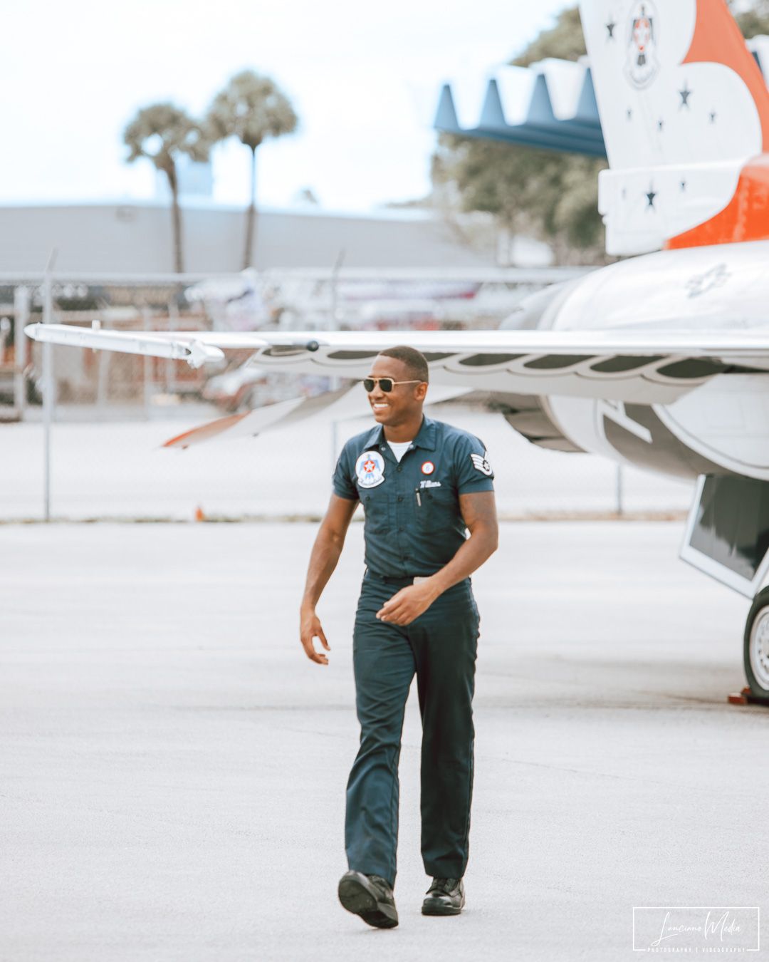 Aviation professional walking on tarmac near aircraft tail.