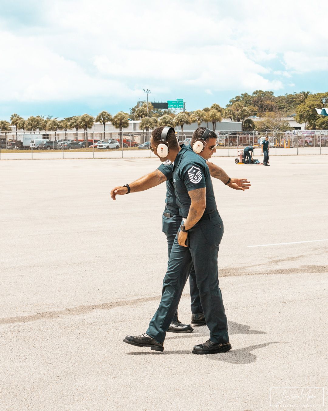 Security personnel patrols an outdoor area wearing a dark uniform and protective gear.