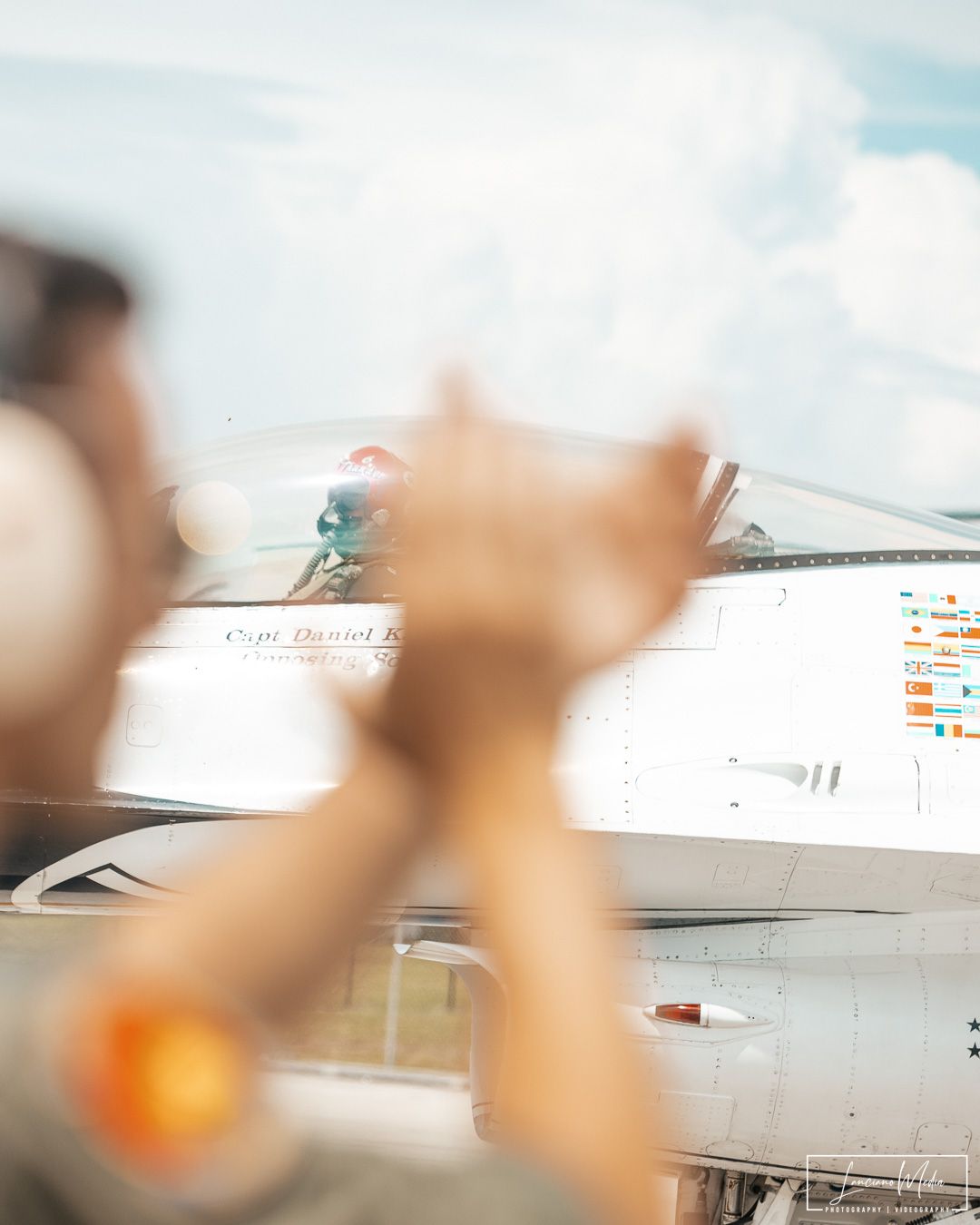 Blurred close-up shot of hands reaching towards a bright sky.