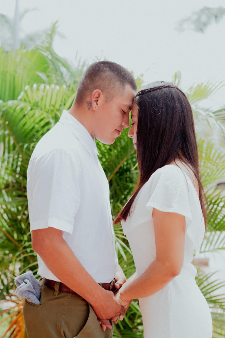 Pareja de recién casados posando en una locación exterior con luz natural suave.