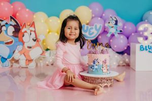Birthday celebration with unicorn-themed cake and colorful balloon backdrop.