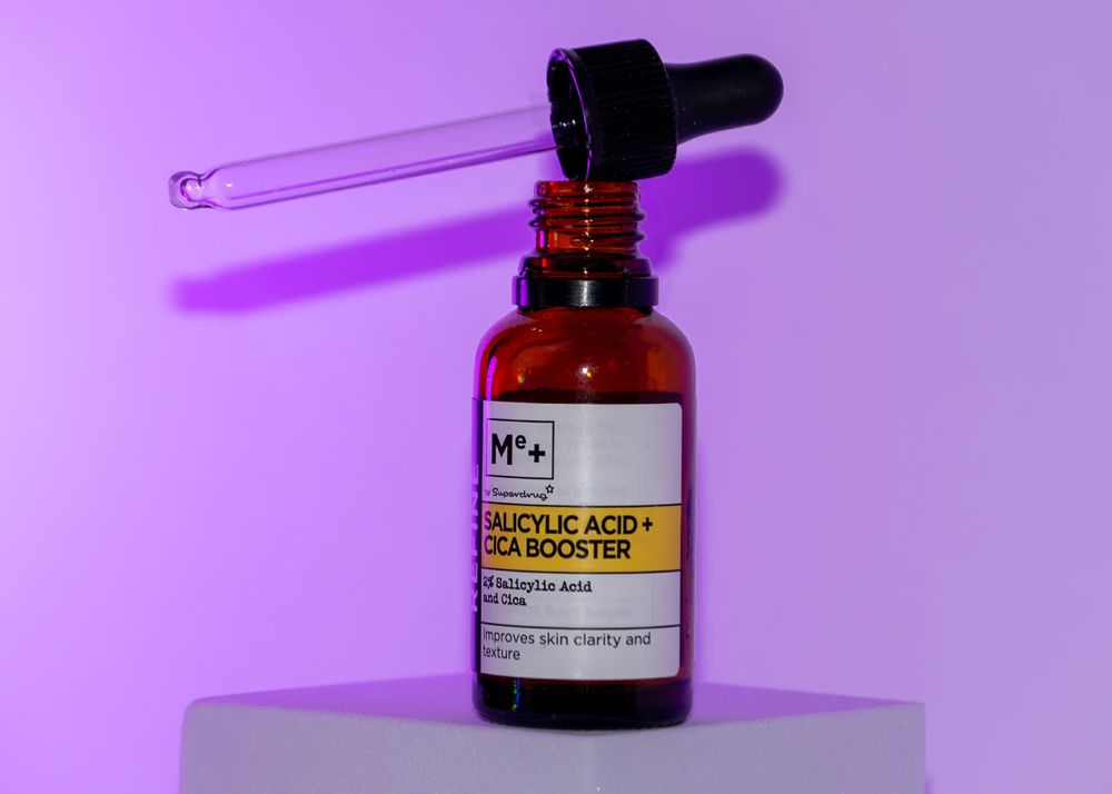Small amber glass dropper bottles with labels against a purple background.
