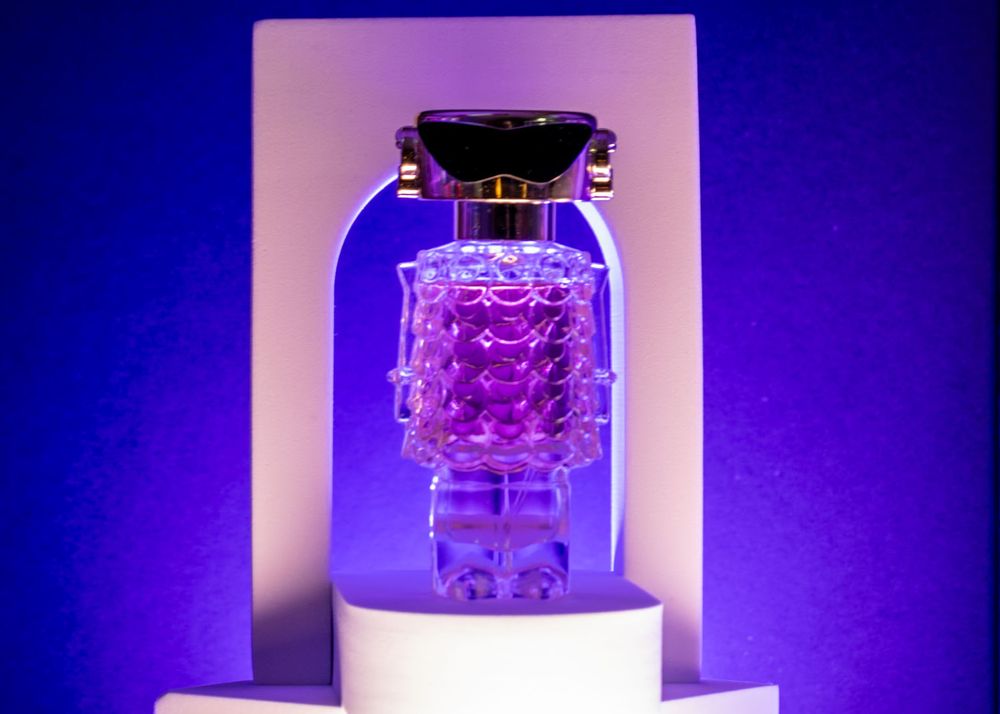 Perfume Bottle illuminated with dramatic blue and purple lighting.