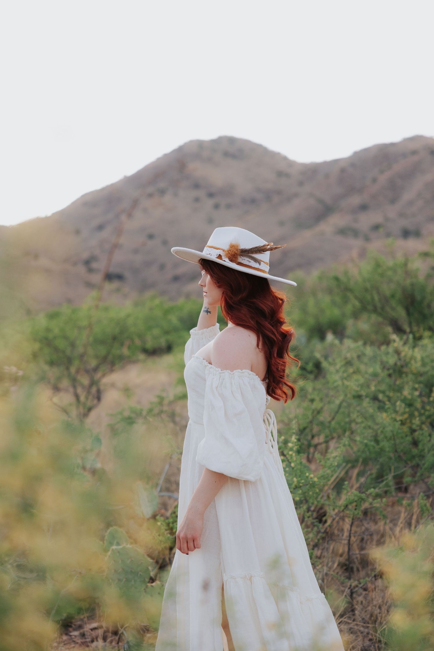 Dreamy white dress photoshoot in desert landscape with mountains.