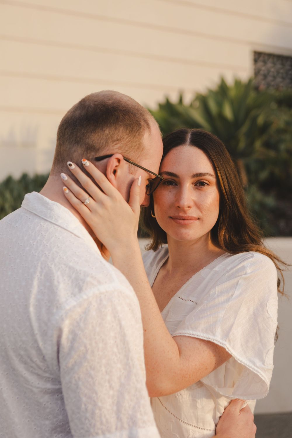 A romantic moment captured between a couple in white outfits at the observatory.