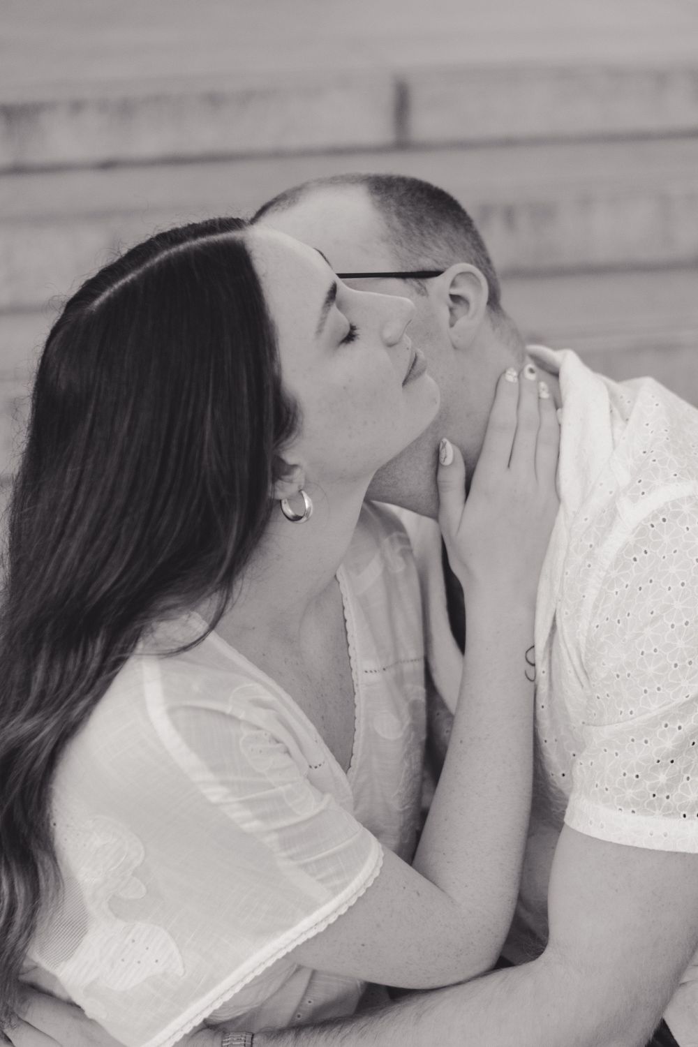 An intimate black and white portrait of a couple sharing a tender moment.