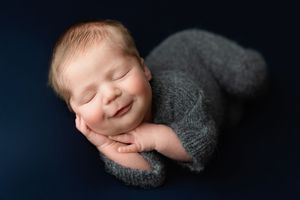 A newborn boy lying on his side with a grey outfit on. Greenville SC newborn photographer. - Easley Sc newborn photographer. Greenville SC p
