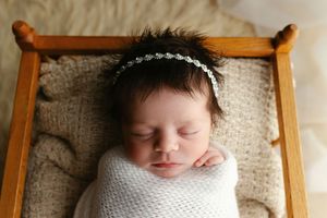A newborn in a wood cradle with a head full of hair. Greenville SC newborn photographer. - Easley Sc newborn photographer. Greenville SC pho