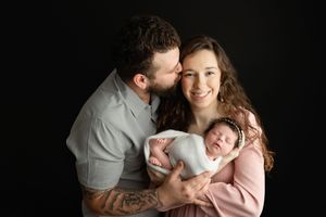 A young family holding their newborn baby. Greenville SC newborn photographer. - Easley Sc newborn photographer. Greenville SC photos