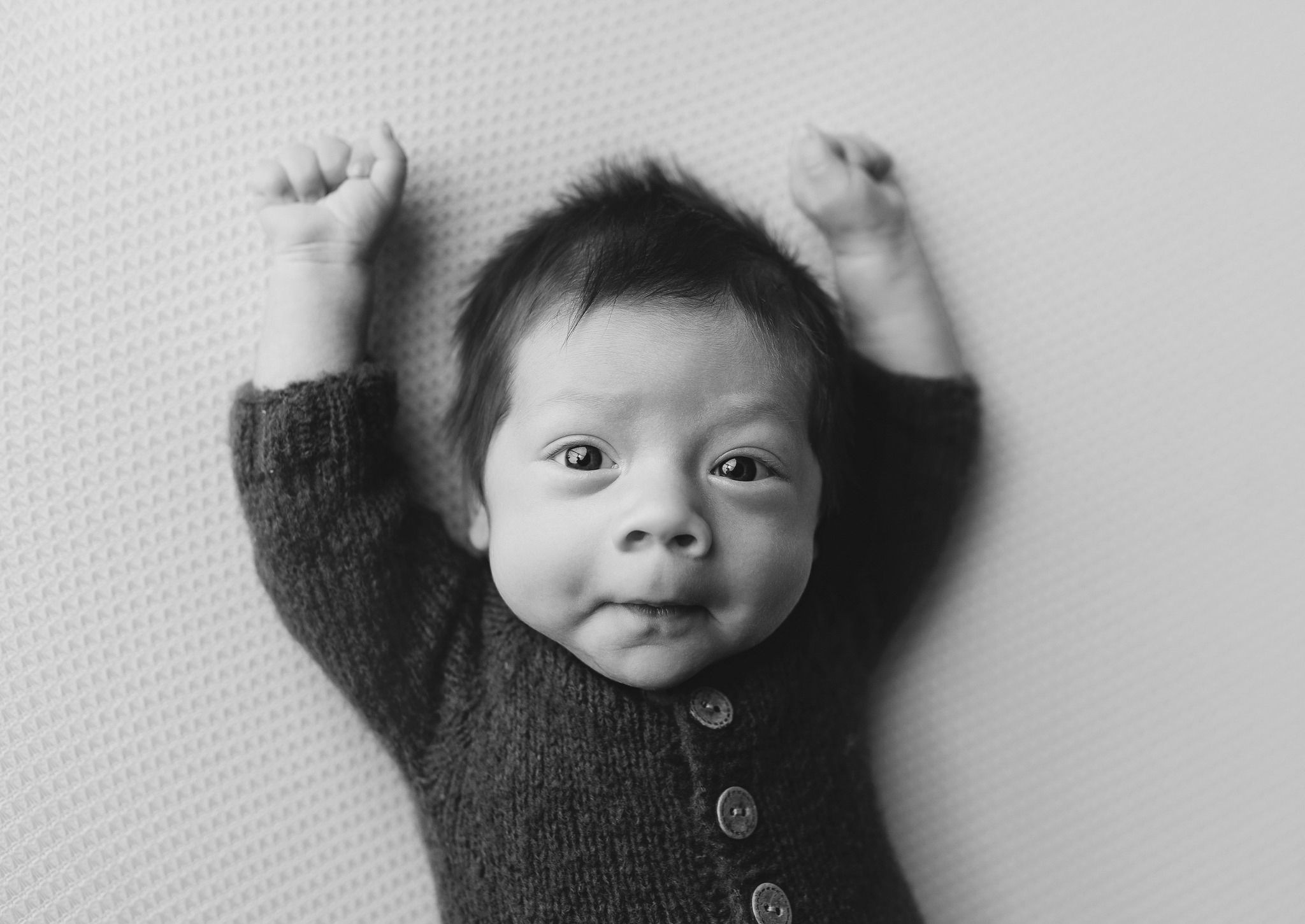 A newborn boy with hands up making a cute face. Greenville SC newborn photographer. - Easley Sc newborn photographer. Greenville SC photos