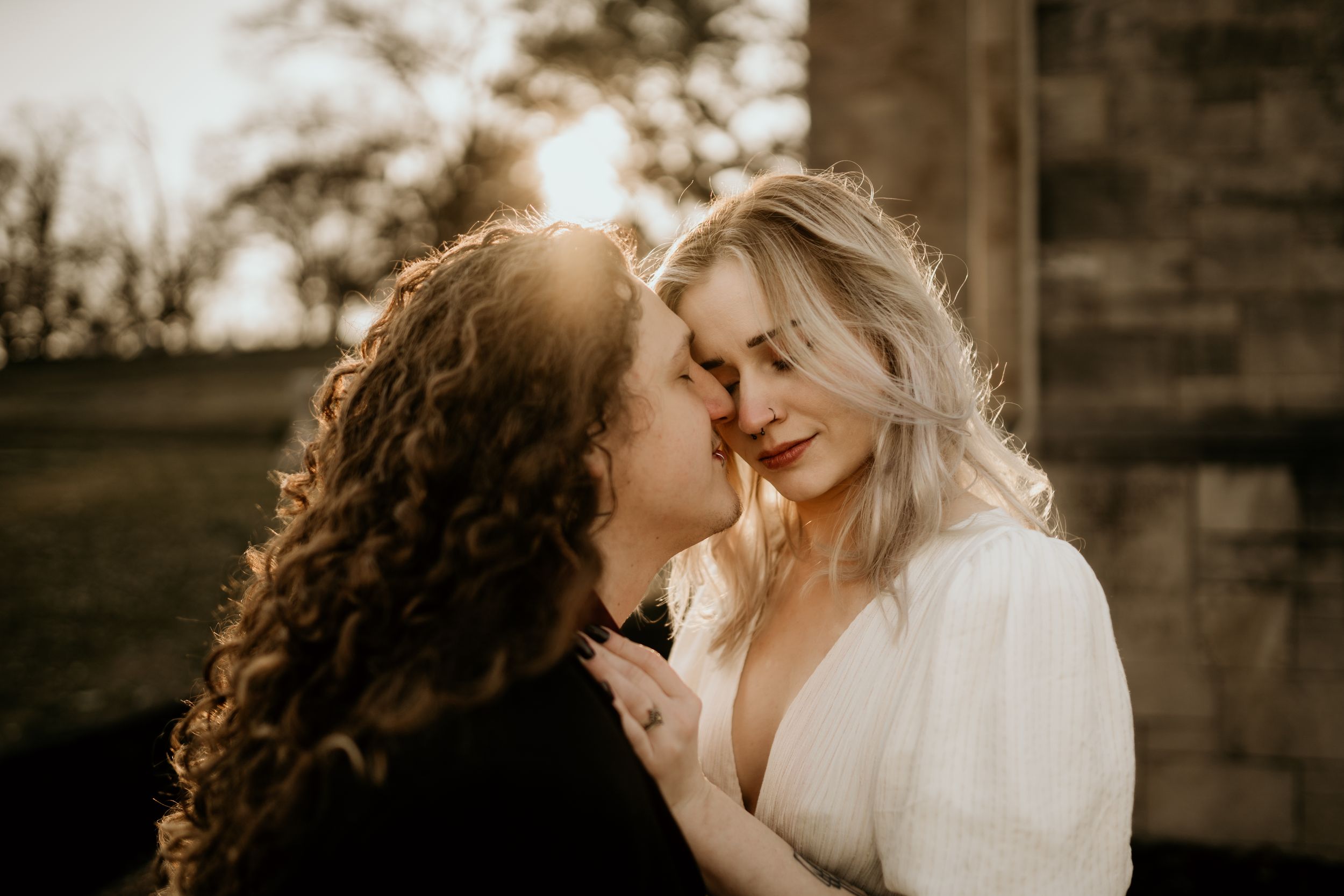 Intimate wedding portraits captured in warm golden light against rustic wooden backdrop.