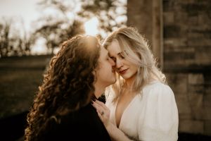 Intimate wedding portraits captured in warm golden light against rustic wooden backdrop.