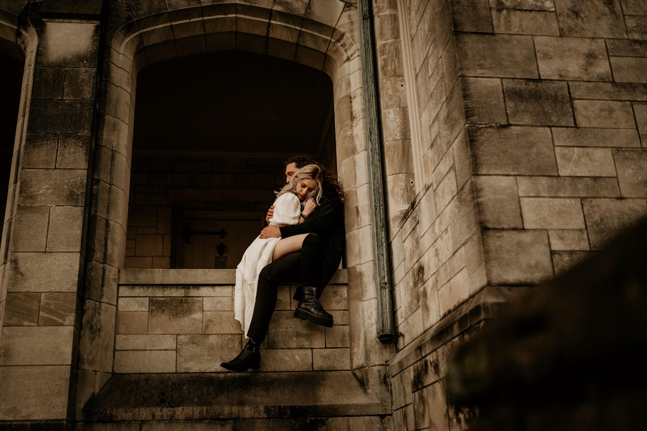 Romantic couple portraits against stone castle architecture.