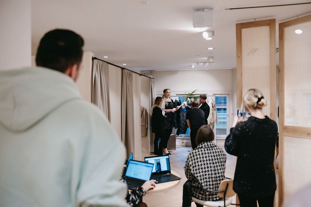 Photography session in progress at a bright retail space with laptops and equipment.