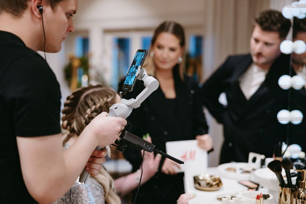 Stylist using hair tools during a professional beauty session at a vanity station.