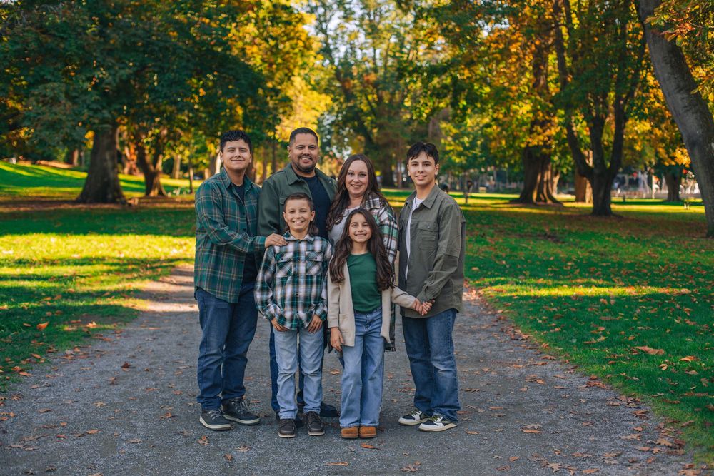 A group portrait of family members standing together on a tree-lined path in autumn. Spokane Liberty Lake Photographer Family Photographer