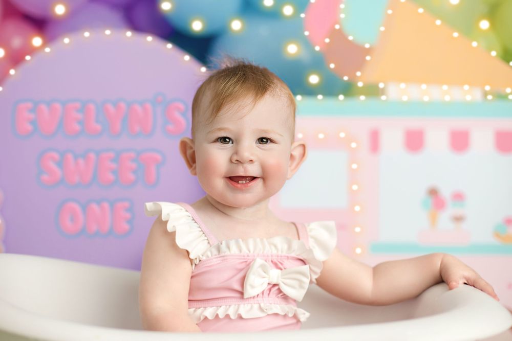Sweet first birthday celebration setup with pastel decorations and string lights creating a festive party atmosphere. sweet one, best cake