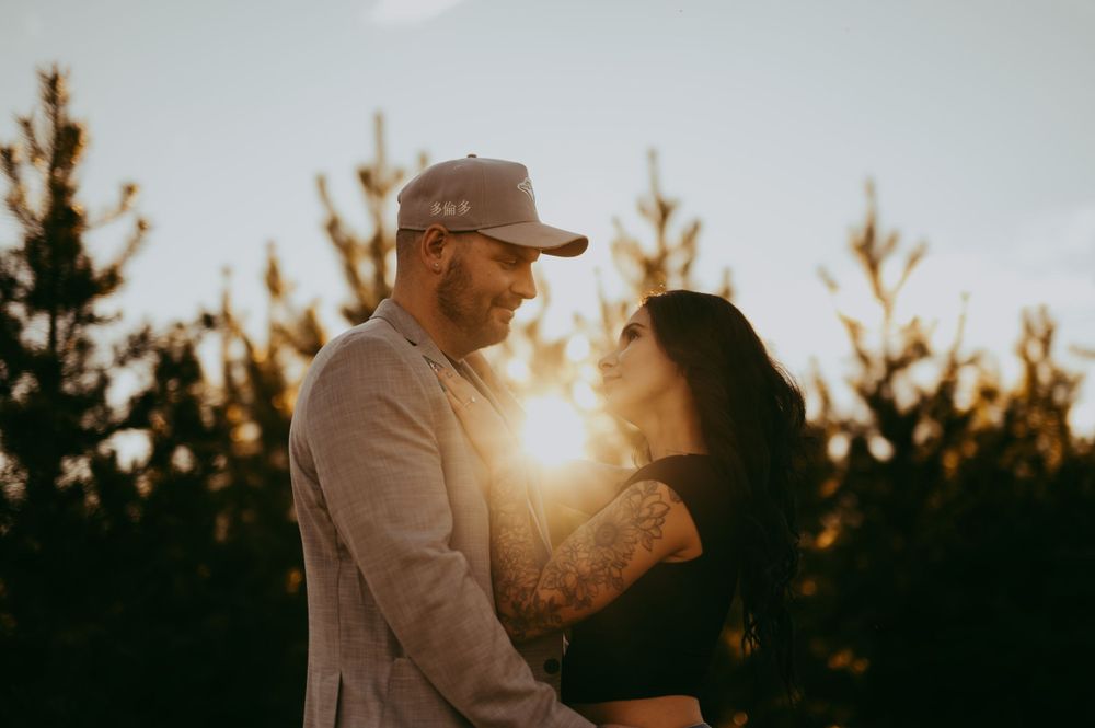 Couple sharing intimate moment at sunset with trees in background at rivers edge in Fort Saskatchewan.
