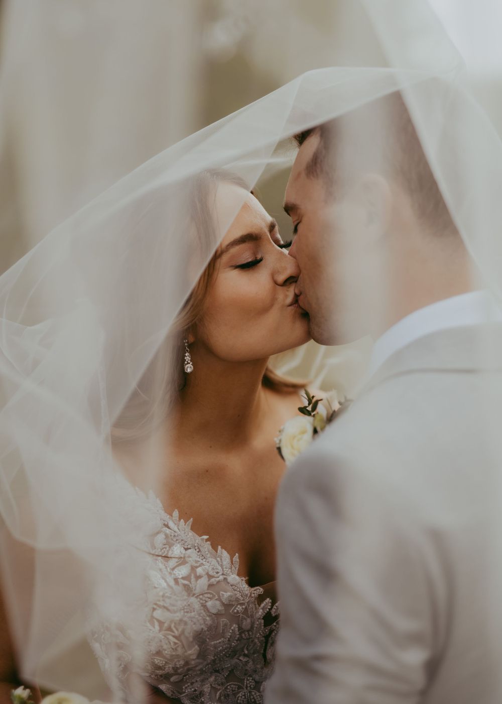 Romantic wedding portrait under flowing veil with soft lighting in Fort Saskatchewan, Alberta .