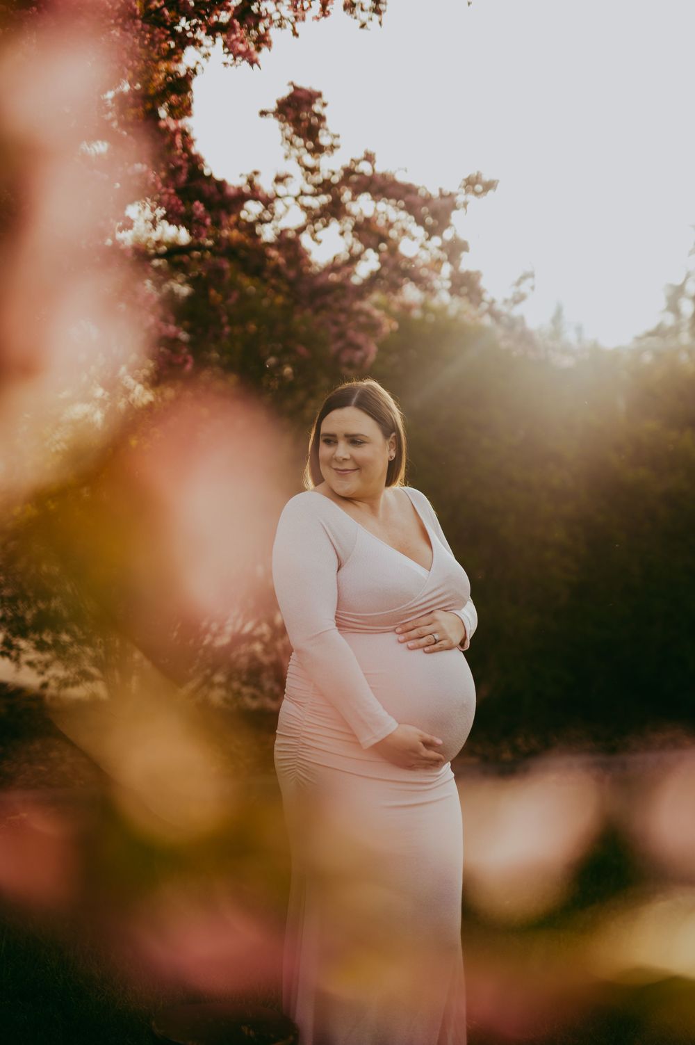 Maternity photoshoot at sunset surrounded by Cherry Blossom flowers in Fort Saskatchewan, Alberta.
