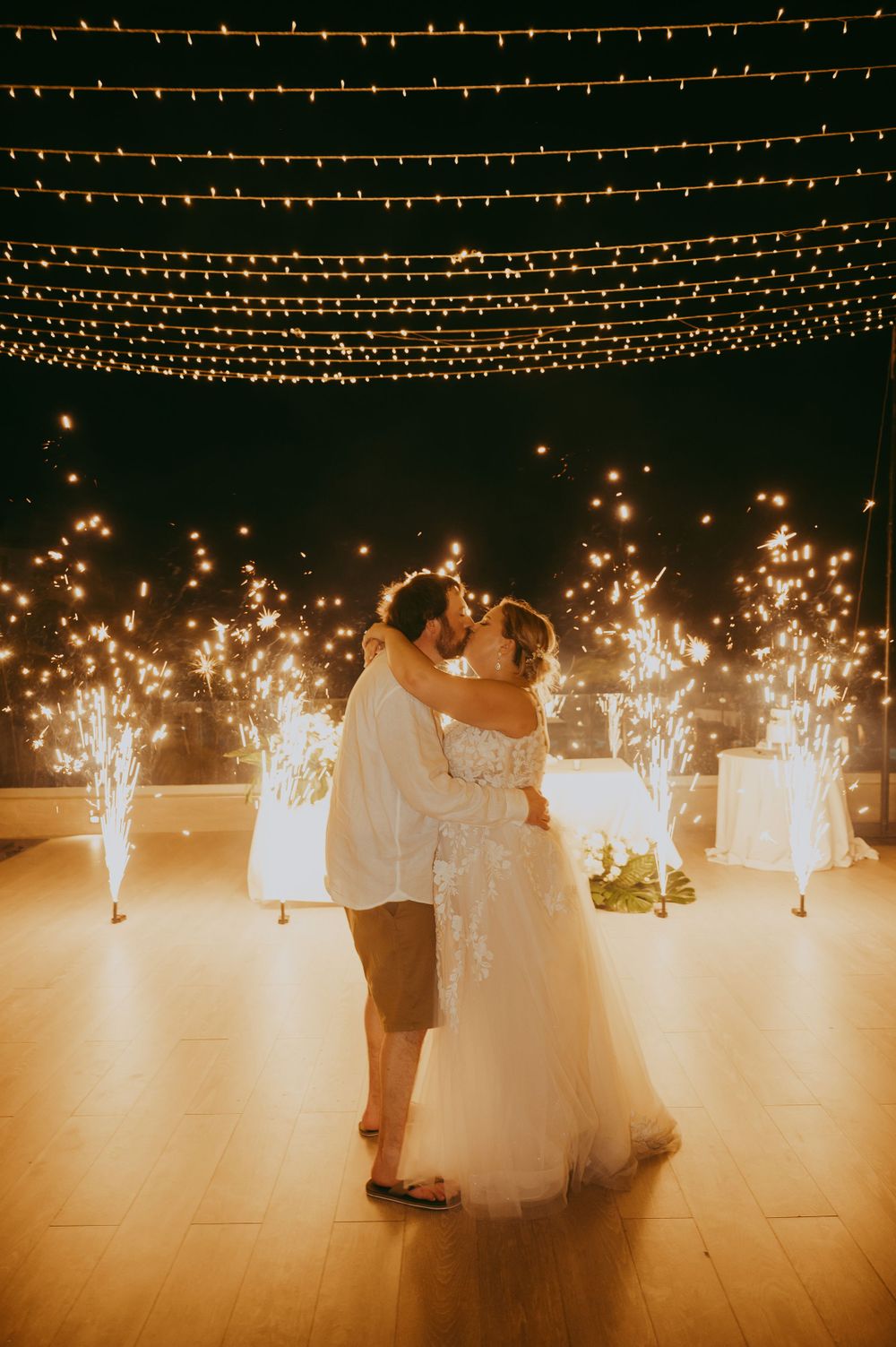 Wedding dance under string lights with sparklers in Mexico creating magical atmosphere.