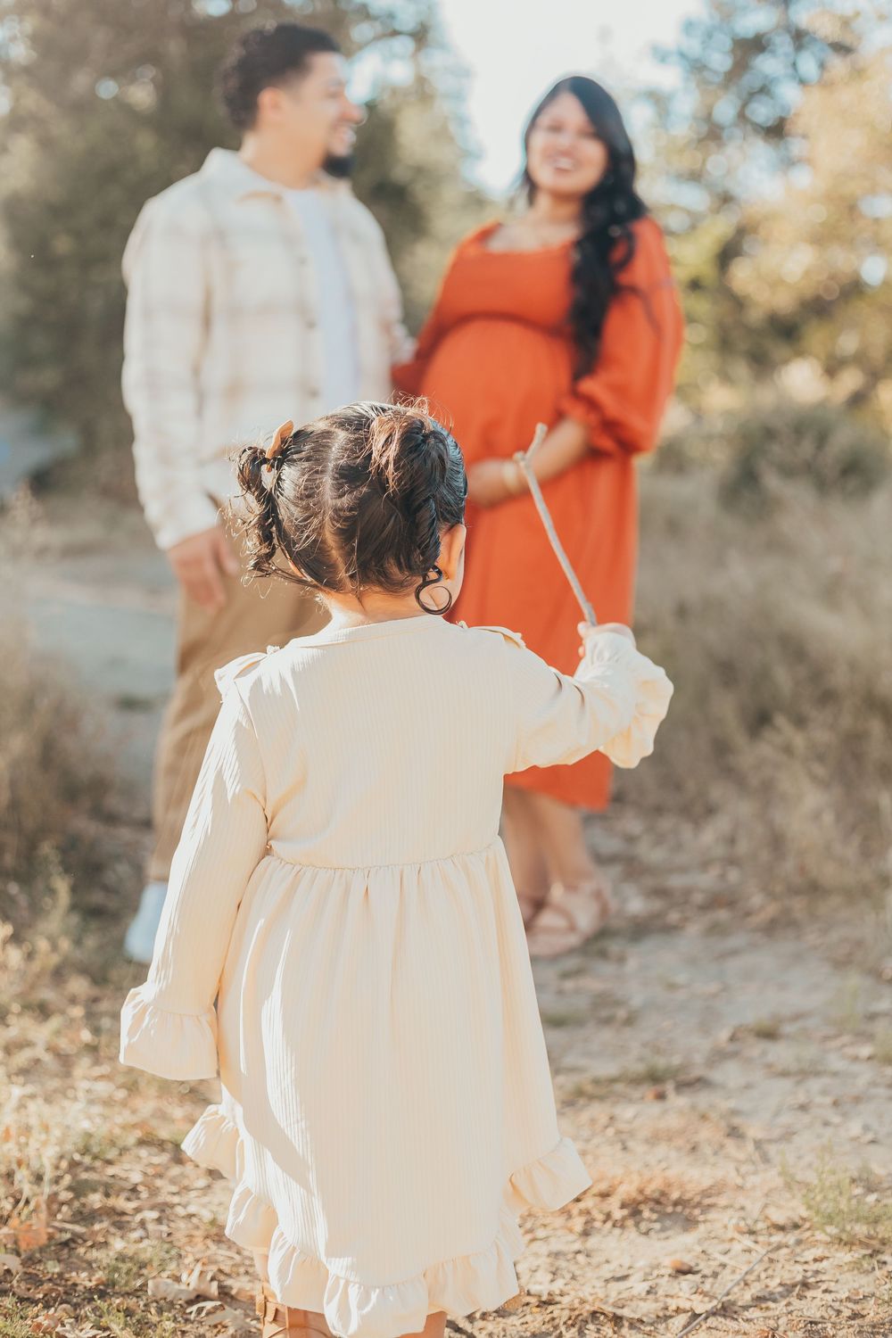 Family photoshoot with small child walking to her parents