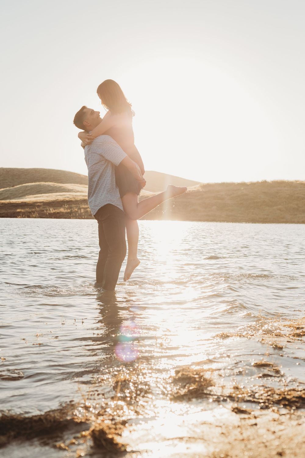 Engagement shoot with a couple hugging in a lake