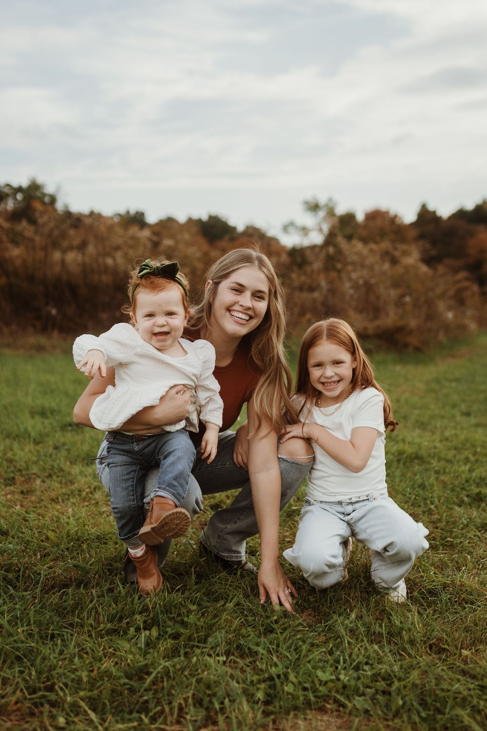 a woman and two young children smiling at the camera