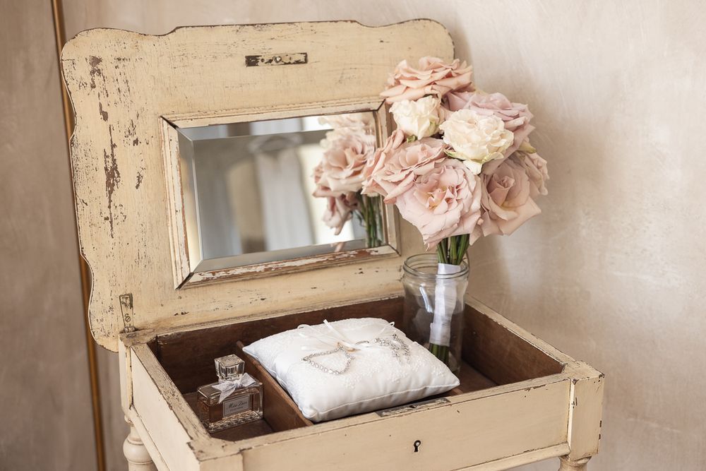 A vintage mirror frame and floral decorations create a romantic shabby chic atmosphere.