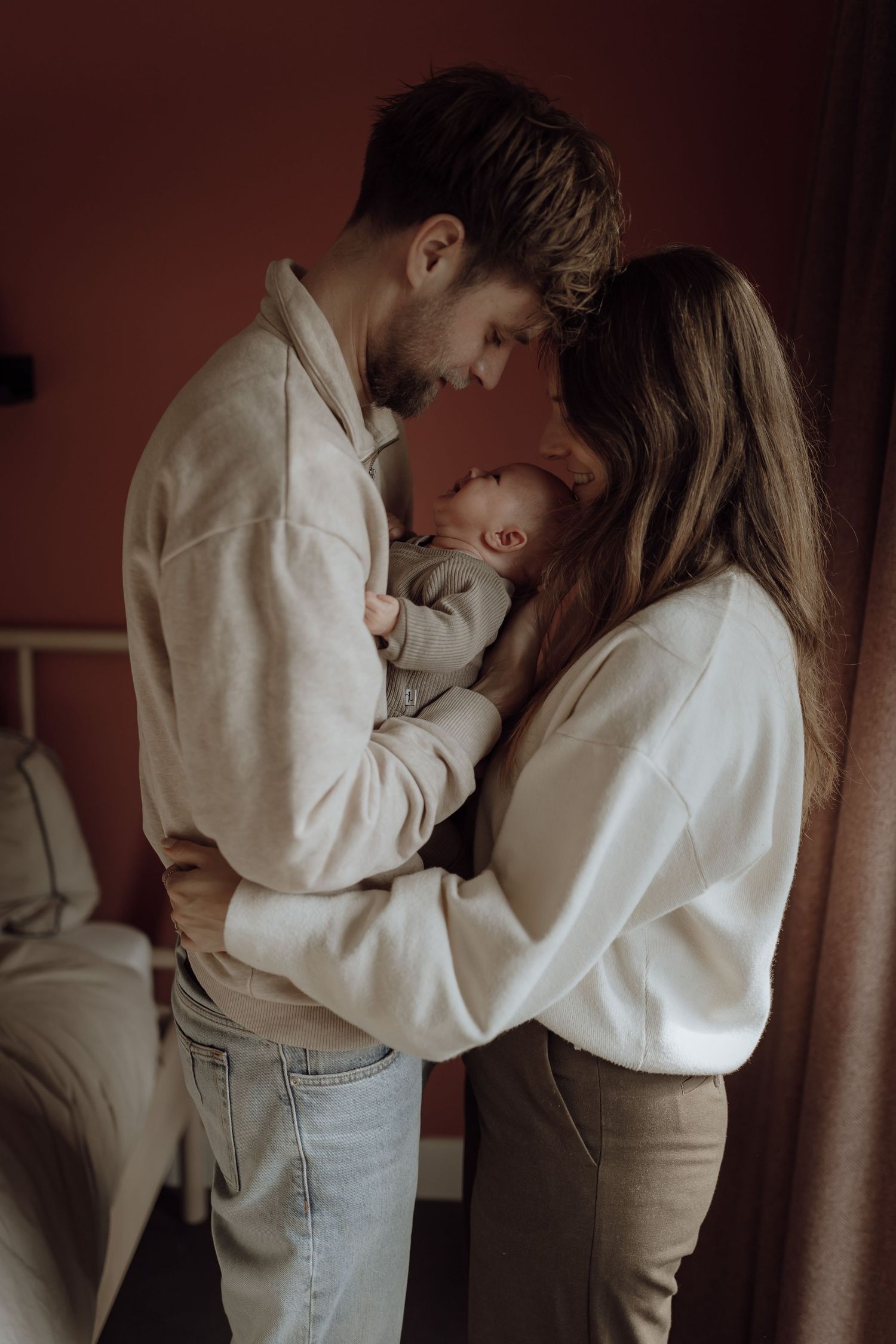 Man vrouw en baby. Man heeft arm om vrouw en baby heen, vrouw houdt baby vast.