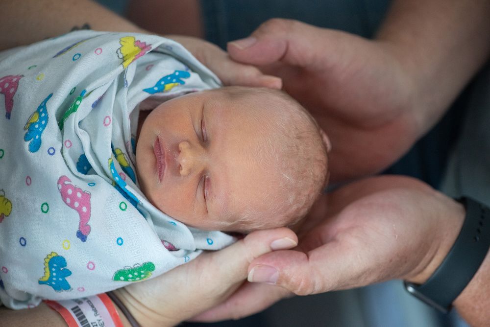 Photo of a newborn taken from above and in her parents hands. Taking in a hospital room  - Kelly Chapman Photographer Perth