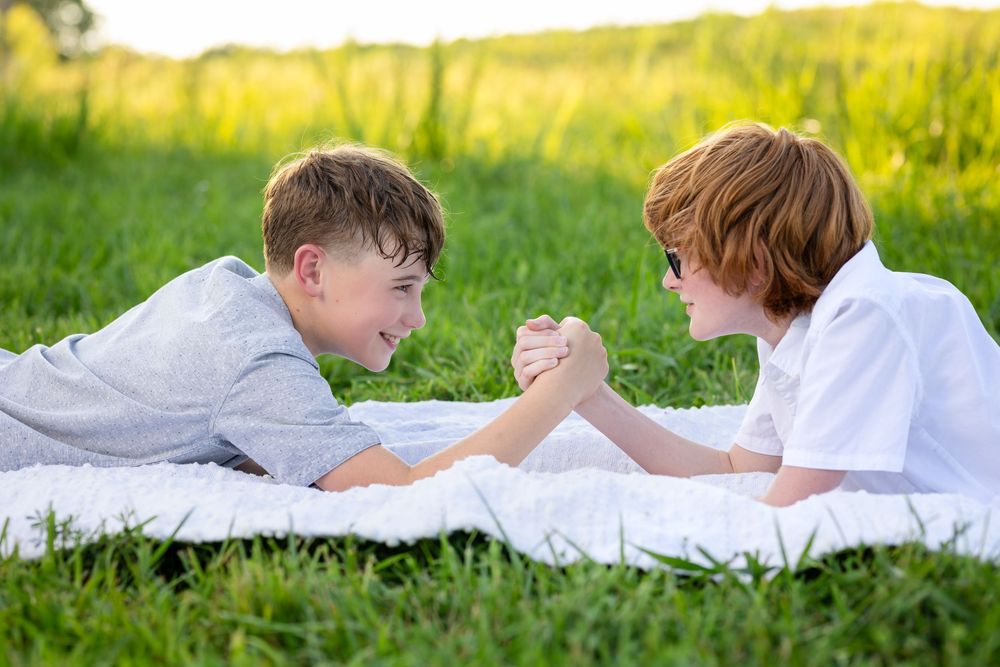 Two brothers lying in a golden field during a family reunion session in Mountain Home, Arkansas