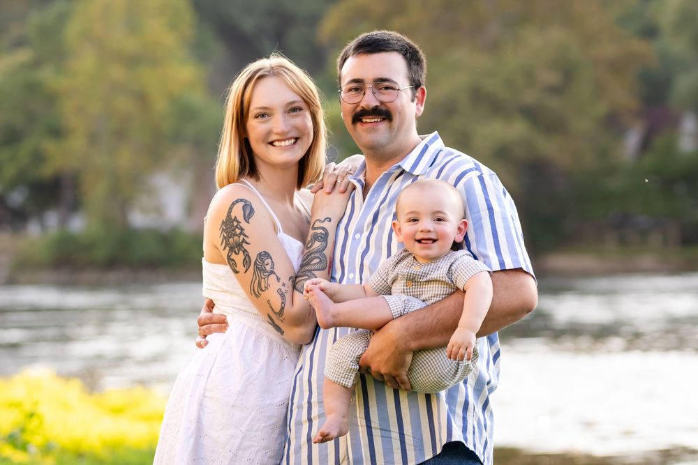 Parents holding their baby with the White River behind them in Cotter, Arkansas