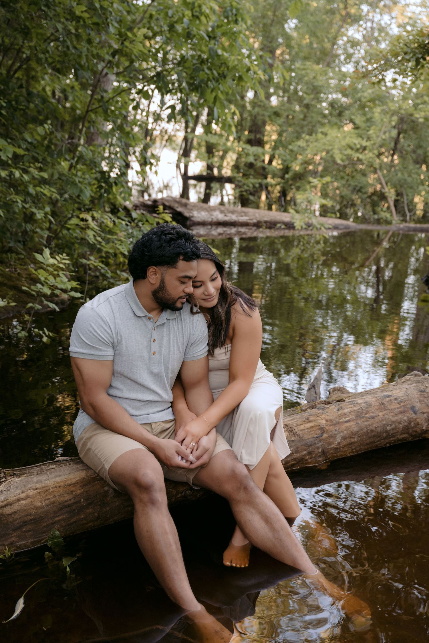 engaged couple cuddling in the woods during an engagement session in Stillwater Minnesota