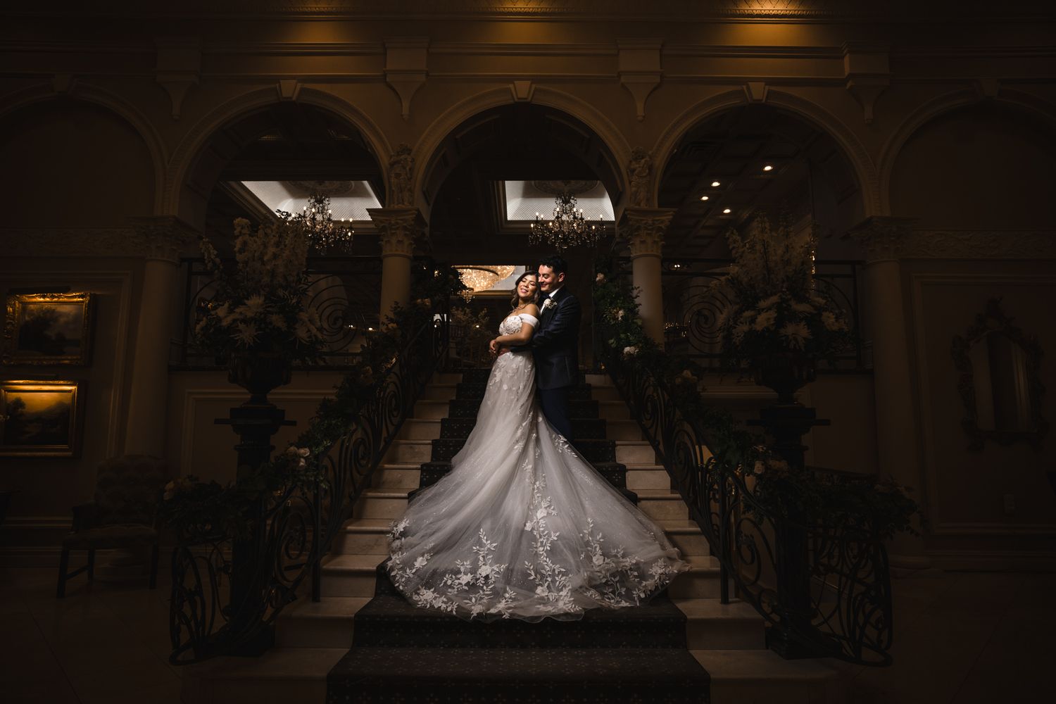 A bride in a flowing white ballgown twirls on a dance floor during a wedding reception.